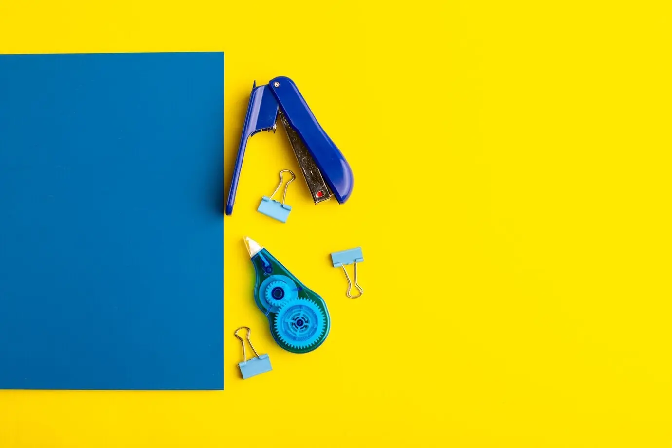 Vorderansicht eines geöffneten blauen Hefts mit Aufklebern auf gelbem Untergrund.